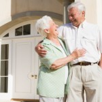 Senior couple standing outside house